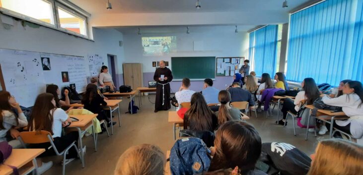 Eine Gruppe von Menschen sitzt an Schreibtischen in einem Klassenzimmer. {{brizy_dc_image_alt imageSrc=