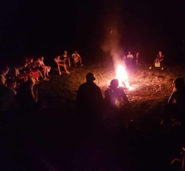 Eine Gruppe von Menschen versammelte sich nachts um ein Lagerfeuer.