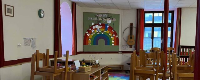 Kindergarten Ein Klassenzimmer mit Holztischen und Stühlen.