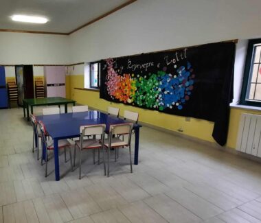 Ein Klassenzimmer mit bunten Wänden und Tischen.
