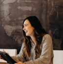 woman sitting around table holding tablet