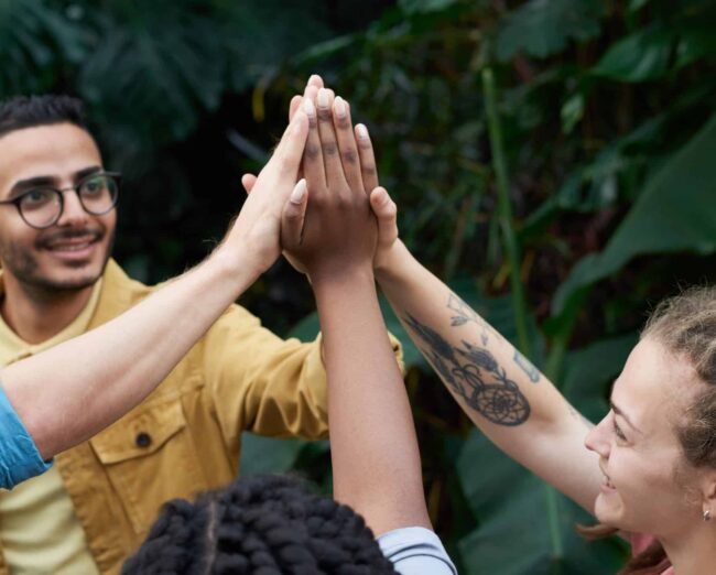 Eine Gruppe von Menschen, die sich gegenseitig High-Fives geben.